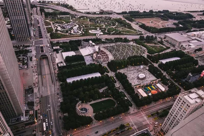 Stunning aerial view of Millennium Park and downtown Chicago cityscape at sunset, showcasing modern architecture and urban greenery.
