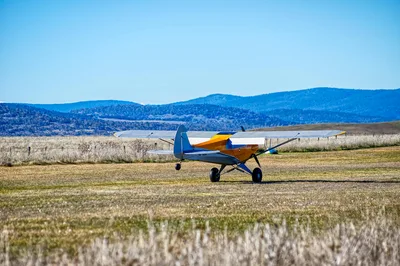 A taildragger bush plane on a grass mountain airstrip