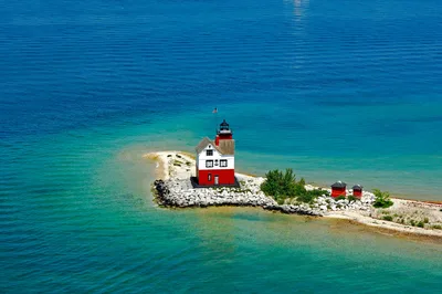 Aerial shot of Round Island Lighthouse on Mackinac Island surrounded by turquoise waters