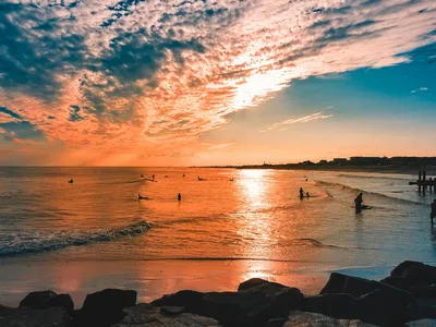 Stunning sunset over Cape May beach with vibrant colors and seashore silhouettes.