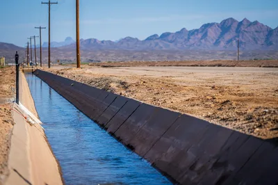 Serene irrigation canal in Yuma, Arizona, with desert mountains in the background