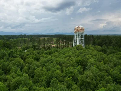 Aerial view of a water tower surrounded by lush green forest in Spartanburg County, South Carolina.
