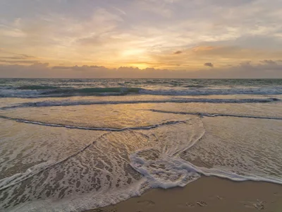 Breathtaking sunset at Vero Beach showcasing golden skies and gentle waves meeting the sand.