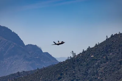 An F-35 fighter jet soaring over the rugged, arid mountains surrounding Kernville, California.