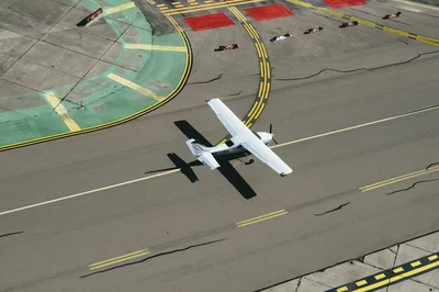 Aerial view of a small aircraft landing on a sun-drenched desert runway